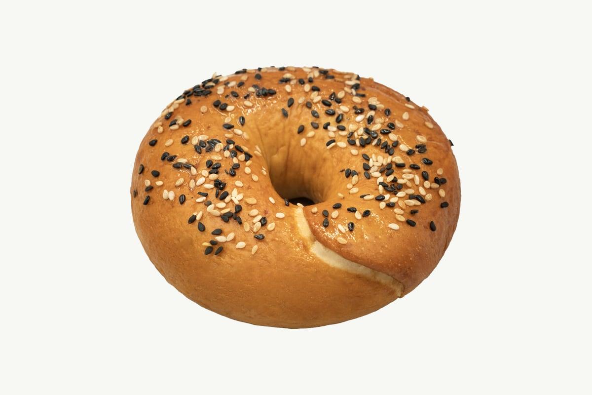 A batch of golden classic bagels arranged on a plain cream background