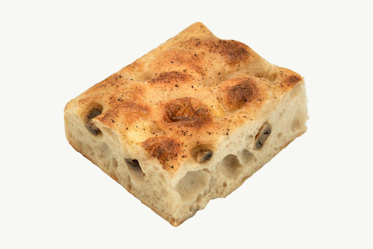 Mushroom focaccia slab on a plain cream surface