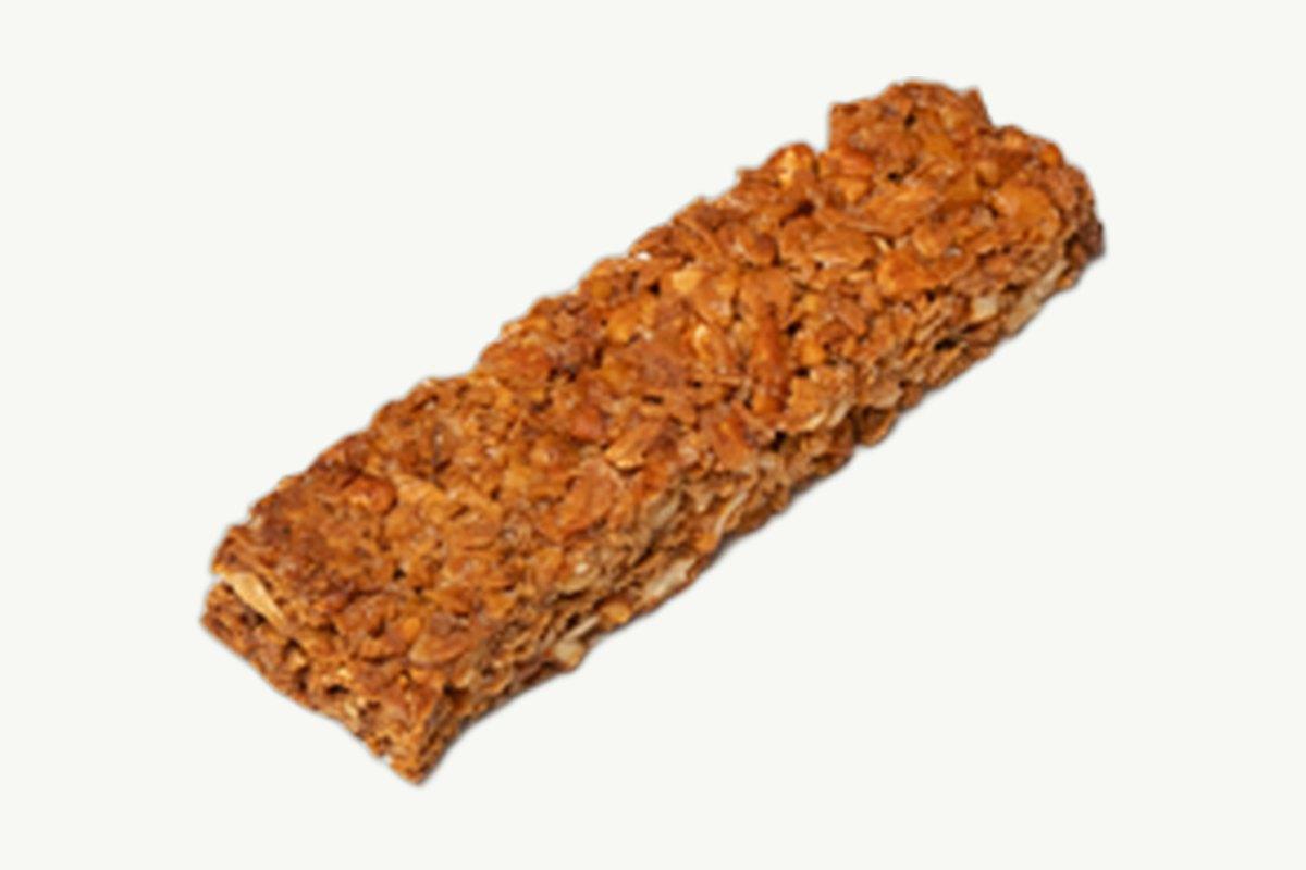 A baked oat granola bar on a plain cream background