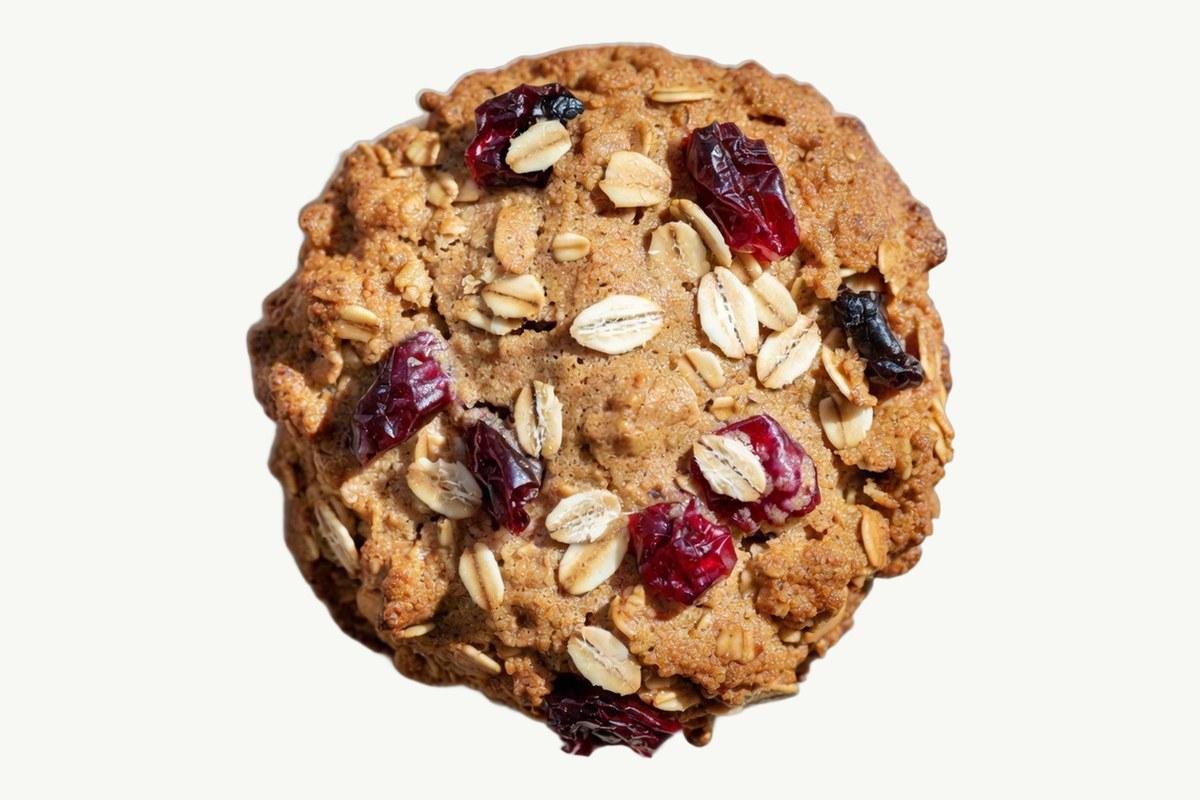 Oats and cranberry cookie on a plain cream background