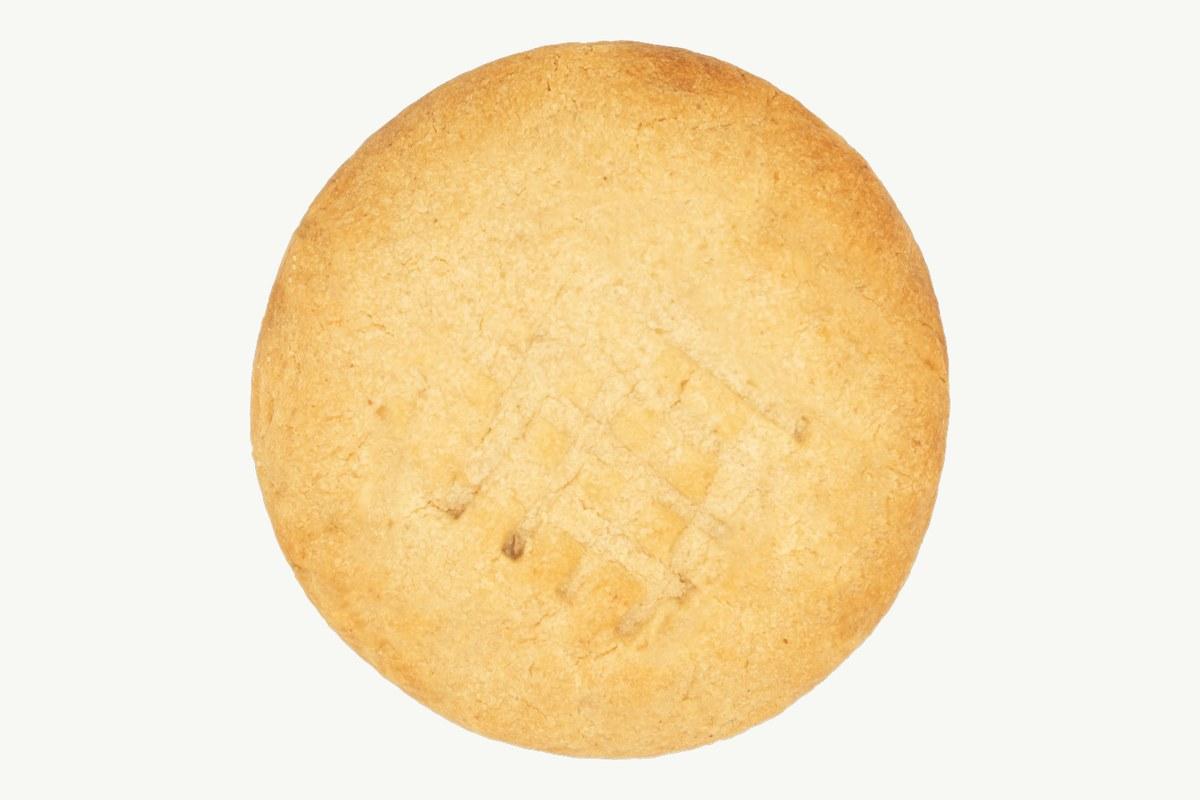 Peanut butter cookie with fork markings on a plain cream background