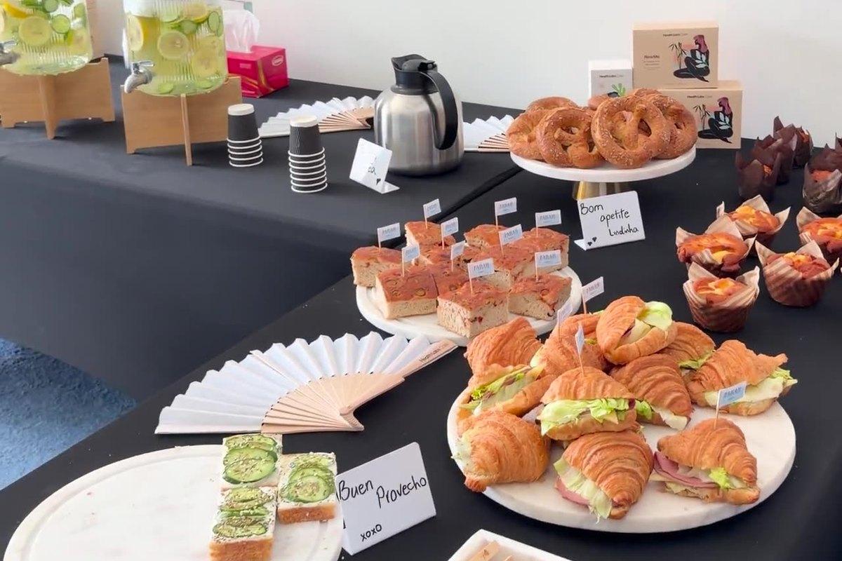 Farah Bakery croissant sandwiches, pretzels, pastries and savoury squares on black-clothed tables at a Health Labs wellness event