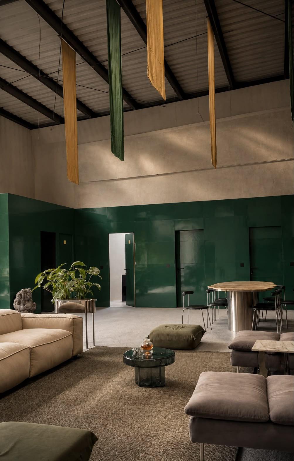The main hall: deep green walls, linen banners hanging from the steel roof, soft seating
