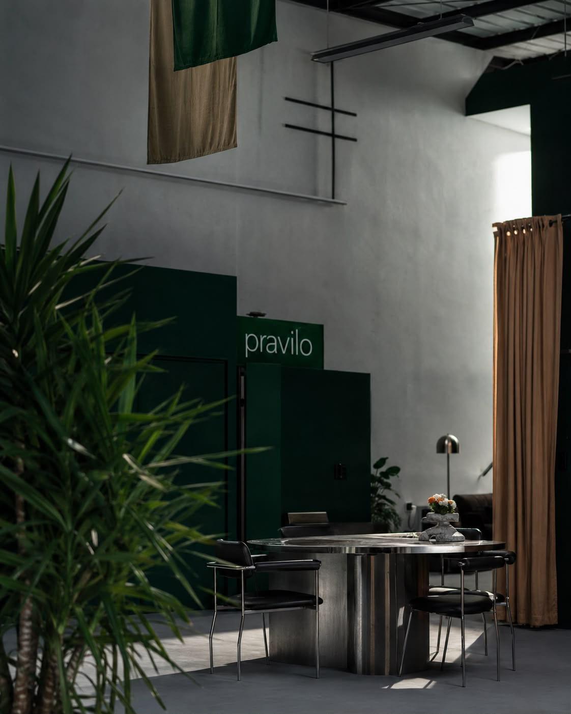 A round steel table set with flowers beneath the Pravilo sign