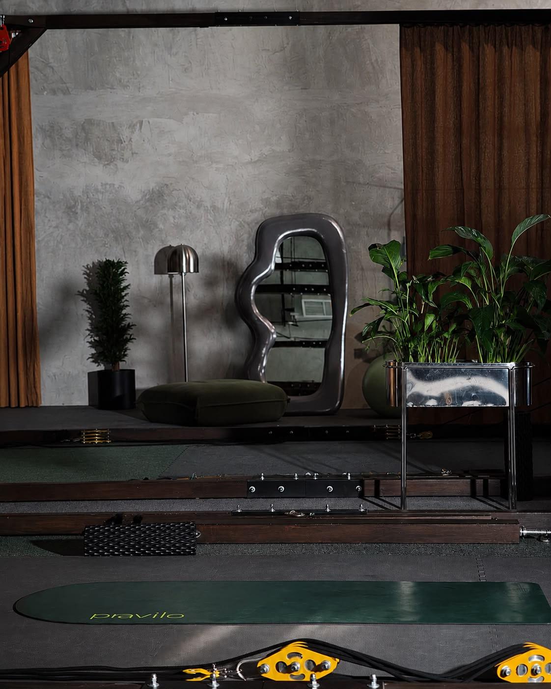 The mat room with its sculpted mirror, floor cushion and green mats